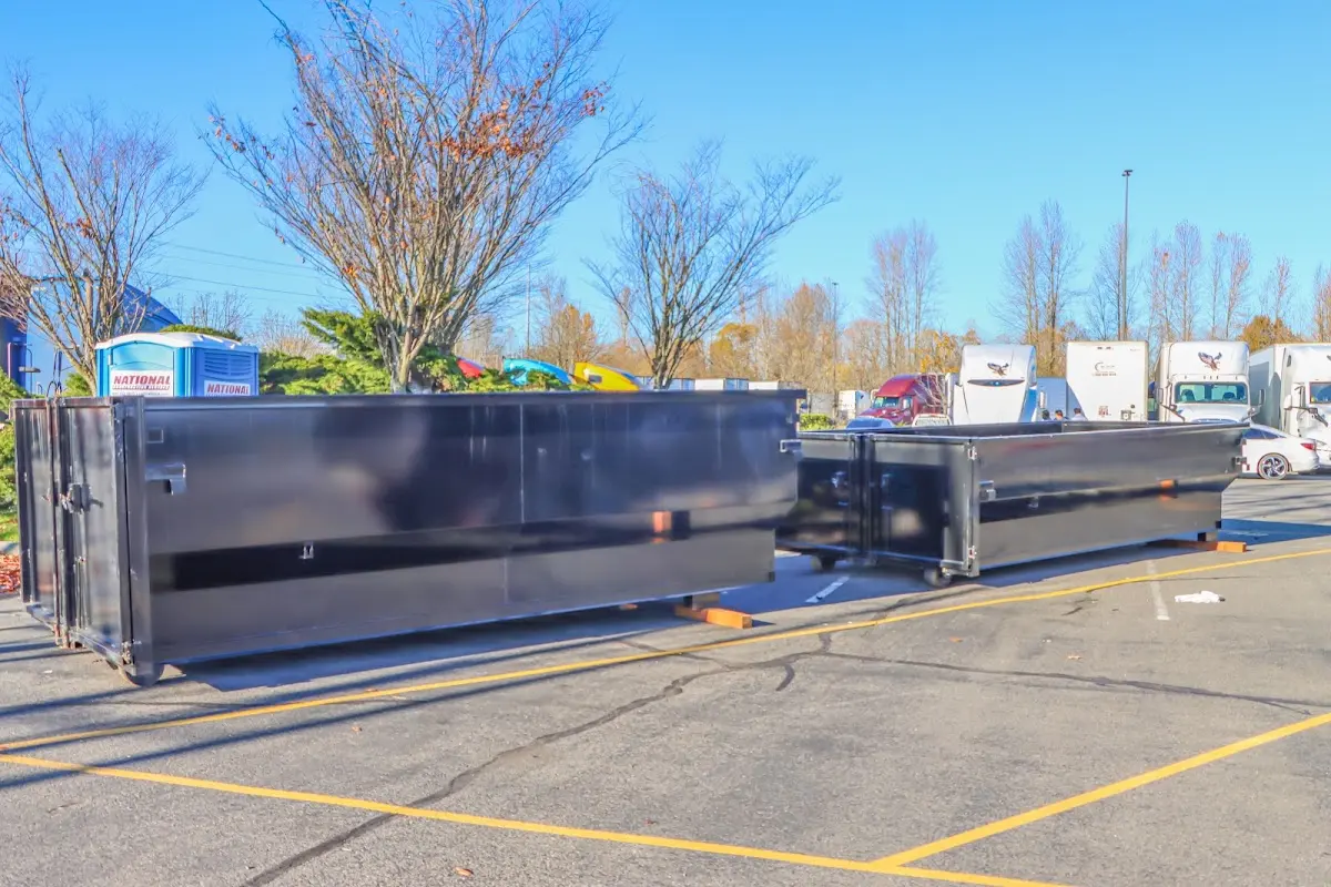 Professional dumpster rental service with roll-off container on residential driveway in Central